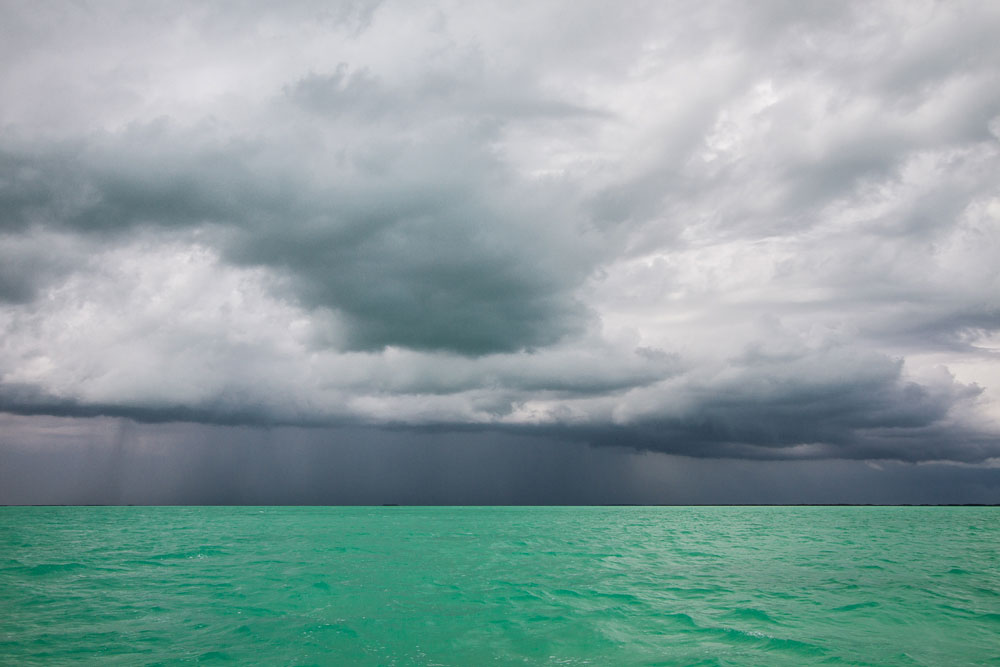 Big dark clouds on the horizon of a bright turquoise sea, the Florida Keys.